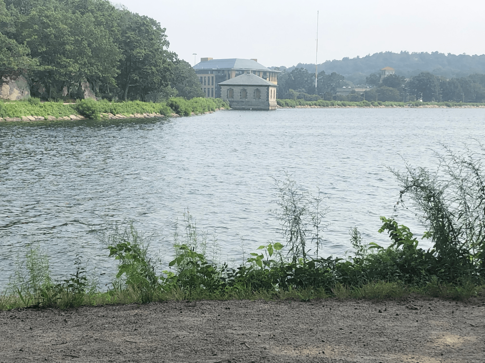 Body of water with a path in the foreground and stone building in the background