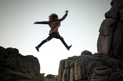 Child leaping from cliff ledge to cliff ledge